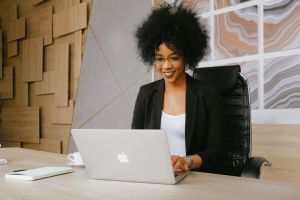 A young woman in a blazer participates in a video conference.