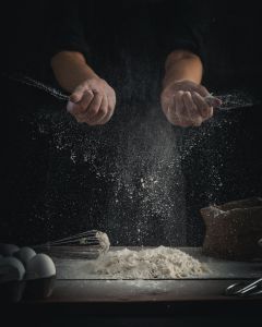 A photo of a person using flour in a baking scenario 